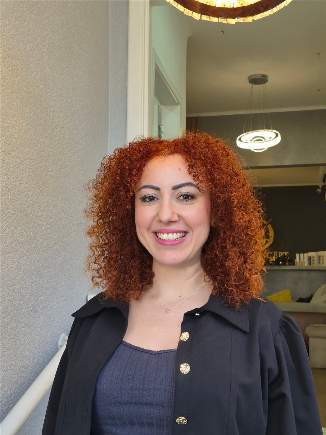 Cliente do RD Hair Concept com cabelo ruivo cacheado